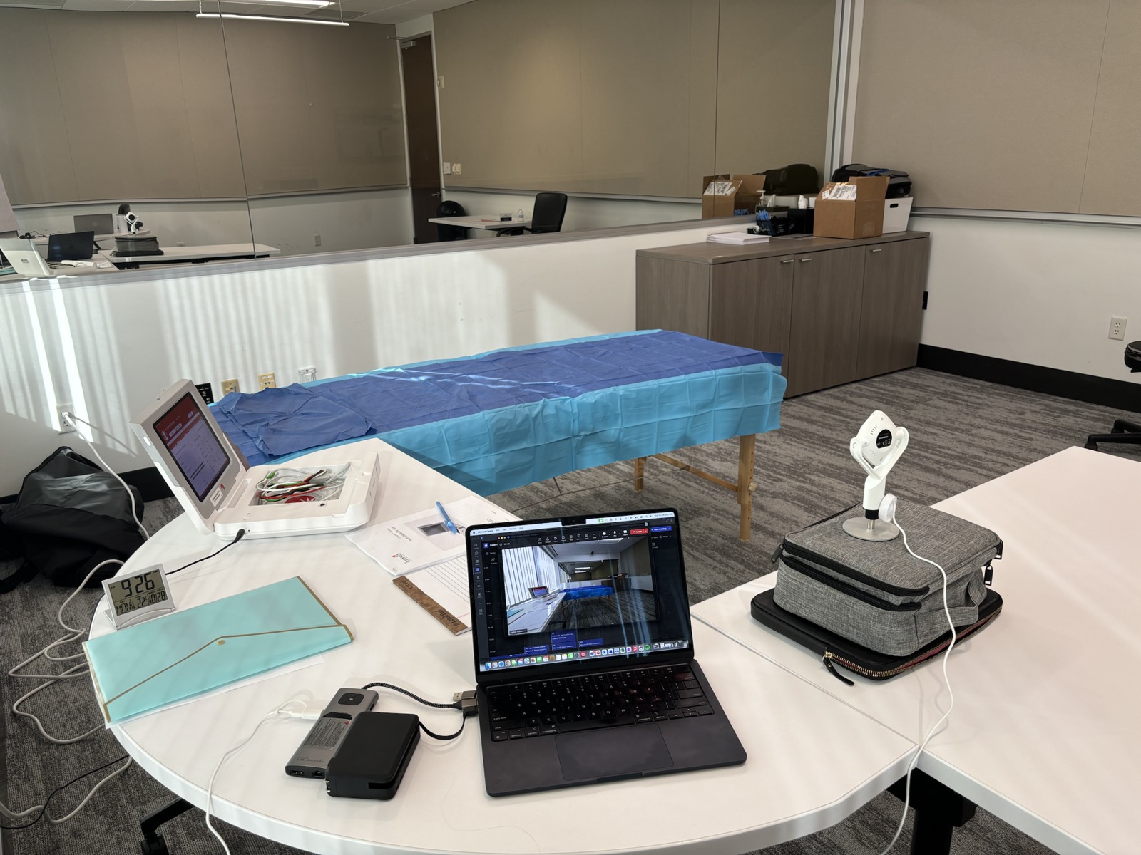 Simulated treatment room setup with procedure table and observation workstation